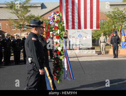 Les membres des services d'urgence de Fort Drum équipes mènent une couronne lors de la cérémonie de dépôt de gerbes au Monument commémoratif du 11 septembre à Clark Hall le Fort Drum, marquant l'anniversaire des attentats du 11 septembre. Fort Drum 11 septembre Cérémonie de dépôt 120911-A-MO557-889 Banque D'Images