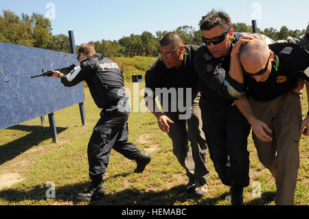 Cuisine américaine et australienne du personnel d'application de la loi et d'escorte des coups de réagir à un VIP pendant une simulation de scénario, le 24 septembre 2012, au cours de l'Assemblée annuelle 2012 de l'agent spécial d'entraînement à Maxton, N.C. Le scénario simulé faisait partie de la formation, des services de protection et de sécurité du transport inclus un VIP tout en réagissant aux coups de feu. L'ASAT, tenue au groupe Gryphon's Fort Bragg Centre d'instruction au combat, rassemble les agents spéciaux du CID, et d'autres membres du personnel dans les domaines militaire et civil de la loi sur la formation sur l'avance de la formation. Cette année, le personnel d'application de la loi de l'Australie et le Canada ar Banque D'Images