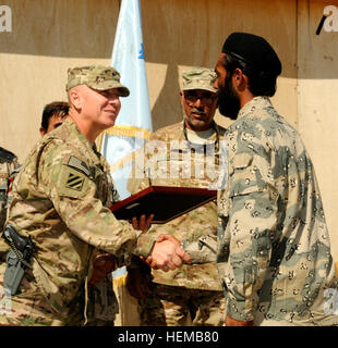 Mirwaise Jamalidin, un patrouilleur de la police frontalière afghane, serre la main de Brig. Le général Chris Hughes, le commandant général adjoint de manœuvre du Commandement régional (Sud), lors d'un risque d'explosion en cours de réduction des diplômes à l'Camp Hero, l'Afghanistan le 22 octobre 2012. 29 Police des frontières diplômée de l risque d'explosion en cours de réduction 121022-A-VC646-165 Banque D'Images