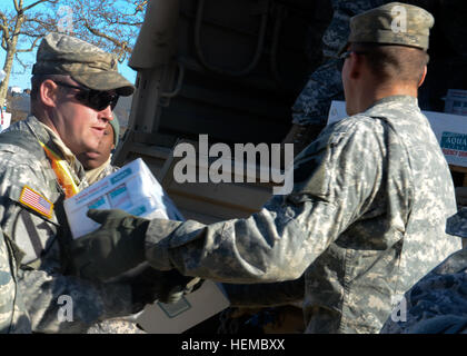 Garde nationale d'armée SPC. Daniel Mcwilliams de Bravo Troop, 2e Escadron, 101e régiment de cavalerie, aide à décharger les cas de l'eau dans Coney Island, New York, N.Y., 9 novembre 2012. McWilliams a participé à une mission qui a pris garde de porte en porte à la recherche d'emploi pour les résidents dans le besoin de nourriture, d'eau et de fournitures médicales. (U.S. Photo de l'armée par la CPS. Jeremy Bennett) New York les soldats de la Garde nationale de fournir l'aide aux résidents de Coney Island 121109-A-QM437-0048 Banque D'Images