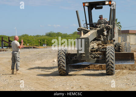 GUANTANAMO BAY, Cuba - Air Force Master Sgt. James Vella dirige l'Air Force Tech Sgt. John Gentile lors du nivellement d'un terrain au cours d'un projet d'amélioration de la route près de la station navale des États-Unis à Guantanamo Bay, aérodrome, 26 janvier 2010. Vella et Gentile sont avec le 106e Escadron de génie civil de la Garde nationale aérienne de New York. Le 106e a entrepris un déploiement de deux semaines de formation à Guantanamo Bay pour faciliter les efforts de secours pour l'opération réponse unifiée. (Foi Guantanamo photo par le Sgt Major de l'armée. Blair Heusdens) NON - Autorisation de diffusion publique. Pour plus d'informations Banque D'Images