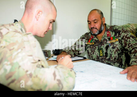 Le sergent Jonathan Davis, l'assurance de l'information sous-officier responsable de l'Administration centrale, et de l'Administration centrale, de l'entreprise 25e Brigade d'aviation de combat, aide les soldats afghans de l'Escadre aérienne de Kandahar pour repérer les caractéristiques du relief de base sur une carte pendant un cours sur la compréhension de la navigation terrestre de base au cours de l'opération d'extension de la formation de cellules à l'aérodrome de Kandahar, Afghanistan, le 21 novembre. Photo de KAW mène des WOC formation avec cabine 25 121121-A-UG106-071 Banque D'Images