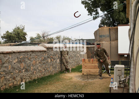 La CPS de l'armée américaine. Christopher Carden emplacements un fer à cheval tandis que la FPC. Gary jeter observe sur une base d'opérations avancée, Shinwar province de Nangarhar, Afghanistan, le 10 décembre 2012. Carden et laïcs sont au service de 1er Bataillon, 327e Régiment d'infanterie, 1e Brigade Combat Team, 101st Airborne Division (Air Assault). (U.S. Photo de l'armée par la CPS. Jenny Lui/libérés) Fers 121210-A-TT389-068 Banque D'Images