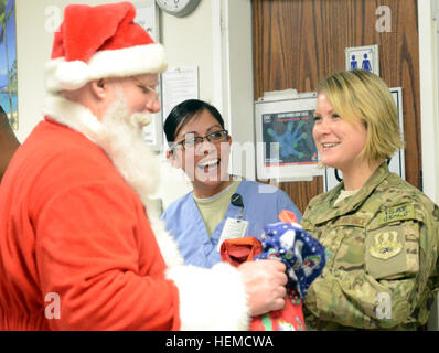 Les infirmières et les médecins militaires travaillant à l'hôpital interarmées de théâtre Craig, l'air de Bagram, en Afghanistan, de recevoir des bas de Noël du Père Noël le 18 décembre 2012. (U.S. Photo de l'armée par le sergent. David J. Overson, Mobile 115e Détachement des affaires publiques) hôpital Santa visites en Afghanistan 121218-A-RW508-005 Banque D'Images