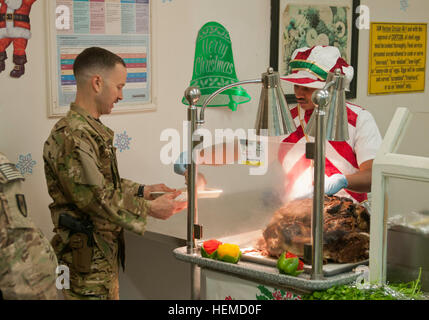 Les membres obtiennent des services freshly sliced steamship round pour le déjeuner de Noël au domaine de l'air de Bagram, le 25 décembre, 2012. La salle à manger accessible à l'élève de la BAF salles pour les vacances, et fait cuire un repas de Noël traditionnel pour plus de 10 000 militaires et civils sous contrat. (U.S. Photo de l'armée par la CPS. Alex Kirk Amen, 115e Détachement des affaires publiques Mobile Service) les membres bénéficient de repas de Noël à Bagram Air Field 121225-A-NS855-001 Banque D'Images