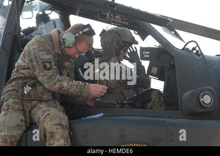 La CPS de l'armée américaine. Miller, Marshall, une gauche AH-64D Longbow Apache le chef d'équipe avec la Compagnie Alpha, 1er Bataillon, 101e Brigade d'aviation de combat, les fréquences de communications des charges dans un calculateur de vol au cours des vérifications de contrôle en amont à la base d'opérations avancée Salerne dans la province de Khost, en Afghanistan, le 16 janvier 2013. (U.S. Photo de l'armée par le Sgt. Duncan Brennan/libérés) Spectre des chefs d'équipage sont fiers du travail bien fait 130116-A-IA071-114 Banque D'Images