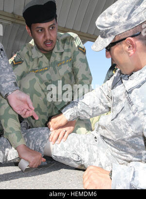 La Kuwait National Guard soldat transport Pvt. Abdal Rahman-Fahad met un garrot improvisé sur la jambe de Sgt. Luis Contreras, un opérateur de transport à moteur avec la 47e compagnie de transport, au cours de la formation en premiers soins au camp côté Tahreer, Koweït, mardi 22 janvier, 2013. Contreras, un El Paso, Texas, résident, s'est associé avec des soldats à travailler sur l'aide de tactiques liées aux accidents de transport. (U.S. Photo de l'armée par le Sgt. William E. Henry, 38e Brigade de soutien) Nous et soldats au Koweït premiers soins pratique 130122-A-TC907-006 Banque D'Images