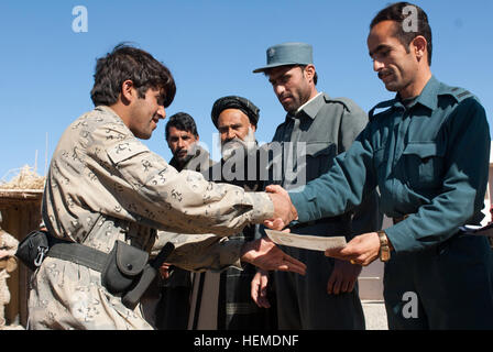 Chef de police de district, Nasibullah, présente un certificat d'achèvement à l'honneur diplômé de l'entraînement contre les IED, un membre d'une patrouille frontalière afghane, lors d'une cérémonie de remise de diplômes en Khugyani Arghistan village, district, province de Kandahar, Afghanistan, le 24 janvier. L'entraînement contre les IED permet aux forces de sécurité nationale afghanes pour accroître la sécurité du district de Arghistan grâce à la détection, au désarmement et à la réduction de leur plus grande menace. (Photo US Army par la CPS. Tyffani L. Chaney) instructeurs afghans mener CIED formation dans le district de Arghistan 130124-A-BC687-001 Banque D'Images