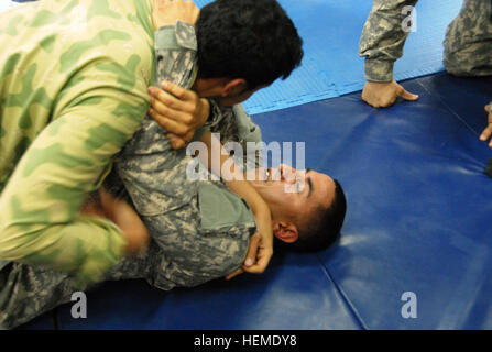 Pvt. Naser S. Alazemi, Kuwait National Guard soldat Transport, tente d'assujettir le Sgt. Luis Contreras, un opérateur de transport à moteur avec la 47e compagnie de transport, au cours de formation combatives au Camp côté Tahreer, le Koweït, le mardi, Janvier 29, 2013. Contreras, un résident d'El Paso, Texas, a pris part à l'événement qui a chargé les deux soldats américains au Koweït et à se défendre contre l'hostilité et de contenir les combattants. (U.S. Photo de l'armée par la CPS. Michael R. Gault, 191e Bataillon de soutien au maintien en puissance de combat) un combat amical 130129-A-RT169-786 Banque D'Images