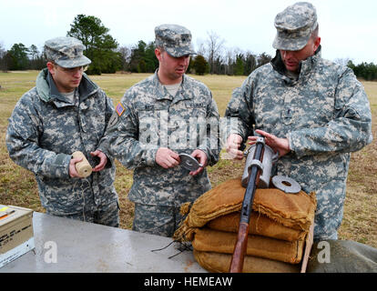 De gauche, de l'armée américaine l'Adjudant-chef Thomas Spicer, Sgt. Bryan a augmenté et l'Adjudant-chef Joseph Swartout, travailler ensemble pour charger un appareil lance-amarre Bridger avec la chaîne, des munitions calibre .45 pistolet modifié et une tige métallique pendant un essai au feu gamme à Fort Eustis en Virginie, le 13 février 2013. Spicer, Rose et Swartout tous affectés à la 7e brigade de maintien en puissance, testé les munitions avant la possibilité d'équiper des navires pendant toute la ligne de l'Armée de champ avec des intermédiaires. (U.S. Photo de l'armée par le Sgt. Edwin Rodriguez/libérés) chiens de munitions à la rescousse ! 870143 Banque D'Images