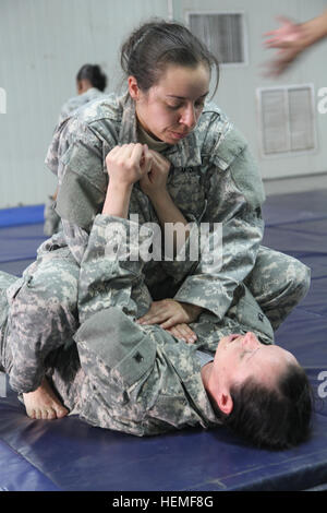 L'armée moderne de niveau 1, les étudiants du programme combatives, SPC. Tara A. Guiterrez et le sergent. Rachel N. Jensen, pratiquer leurs nouvelles compétences sur le mardi 5 mars 2013, au Camp Arifjan, au Koweït. Les deux 38e Brigade de soutien militaires faisaient partie de la première classe que les instructeurs à partir de la 47e compagnie de transport enseignées durant leur déploiement au Koweït. L'Armée américaine photo par le Sgt. 1re classe Tina R. Eichenour, 38e Brigade de soutien combatives, Army 130305-A-RW051-150 Banque D'Images