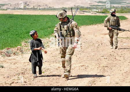 Royal Australian Air Force le Lieutenant se Drewitt-Smith parle avec un garçon afghan local alors qu'il effectuait une patrouille à pied à Tarin Kowt dans la province d'Uruzgan, Afghanistan, le 31 mars 2013. Les membres de la Royal Australian Air Force qui effectuaient une patrouille de défense au sol afin de fournir à la défense en profondeur et de prendre conscience de la population locale à proximité de la base. (U.S. Photo de l'armée par le Sgt. Jessi Ann McCormick/libérés) de la Royal Australian Air Force conduite des forces de sécurité patrouille à pied 130331-A-FS372-017 Banque D'Images