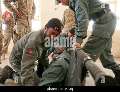 Policiers afghans avec le bataillon de réserve Qalat, placer un policier sur une civière au cours d'un exercice pratique en combat un épargnant de vie class enseignés par des infirmiers de l'armée américaine avec le 1er Bataillon, 41e Régiment d'artillerie, 1st Armored Brigade Combat Team, Combined Task Force Raider, 3e Division d'infanterie et de l'équipe d'assistance aux forces de sécurité 21, 29th Infantry Brigade Combat Team, Hawaii, de la Garde nationale à Qalat dans province de Zabul, Afghanistan, 3 avril 2013. Les policiers vont former le reste de leur bataillon, à l'aide première tactique dans les mois à venir. (U.S. Photo de l'armée par la CPS. Tim Morgan/relâché Banque D'Images