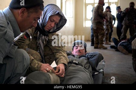 Le capitaine de l'armée américaine Nicole Ballentine, un adjoint au médecin du 1er Bataillon, 41e Field Artillery, 1st Armored Brigade Combat Team, Combined Task Force Raider, 3e Division d'infanterie, enseigne aux policiers afghans avec le bataillon de réserve, Qalat comment appliquer un pansement d'une blessure à la jambe au cours d'un Combat épargnant de vie classe à Qalat dans province de Zabul, Afghanistan, 3 avril 2013. Les policiers vont former le reste de leur bataillon, à l'aide première tactique dans les mois à venir. (U.S. Photo de l'armée par la CPS. Tim Morgan et de la police en uniforme afghane) Parution devenir Life Savers 904789 Combat Banque D'Images