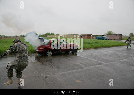 Le sergent de l'armée américaine. Alexis Camacho, affectés au siège de l'entreprise et de l'Administration centrale, le Grand quartier général des Puissances alliées en Europe (SHAPE), du bataillon de l'Armée US Organisation du Traité de l'Atlantique Nord (OTAN) Sauts Brigade dans l'air comme un dispositif explosif de pyrotechnique Effects Simulator(IEDES) explose dans une voiture. L'unité est d'effectuer des opérations de patrouille pour leur certification comme Observers-Controllers dans le Benelux Formation Support Alliance Centre d'entraînement, Chievres, Belgique, le 16 mai 2013. (U.S. Photo de l'armée par Pierre-Etienne Courtejoie/libérés) FORME HHC BN 13051 formation de familiarisation OC Banque D'Images