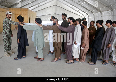 Un soldat de l'Armée nationale afghane s'aligne de nouvelles recrues de la police locale afghane en formation à un centre de formation en Zharay ALP district, province de Kandahar, Afghanistan, le 22 mai 2013. Les forces d'opérations spéciales américaines en partenariat avec ANA et instructeurs de la Police nationale afghane et enseigner les compétences militaires tactiques pour les recrues pour les aider à assurer la sécurité de leurs villages. (U.S. Photo de l'armée par le sergent. Kaily Brown/ libéré) visite de contrôle 130522-A-S772-006 Banque D'Images