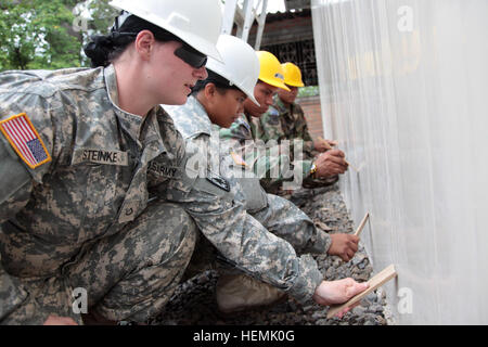 Circuit de l'armée américaine. Erica Steinke (extrême gauche), avec le 829th Engineer Company, et la CPS. Alyssa Sablaon (centre-gauche), avec la 437e Compagnie médicale, travailler avec les ingénieurs de l'armée salvadorienne Adelso Tarres (milieu à droite) et Edgard Ventura (extrême droite) pour nettoyer les murs d'une nouvelle école à l'appui de l'Au-delà de l'Horizon (BTH) à Sonsonate, El Salvador, le 29 mai 2013. BTH est un chef d'état-major interarmées-dirigé, U.S. Southern Command-parrainé la formation sur le terrain et de l'exercice humanitaire dans lequel des troupes spécialisées dans l'ingénierie, de la construction et de la santé des Banque D'Images