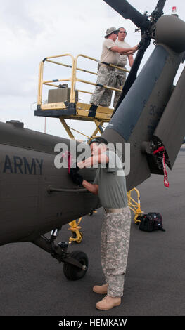 Le Sgt. Kaylen Hayashi (avant), un mécanicien, Black Hawk preps la queue d'un UH-60 Black Hawk pour le transport aérien alors que le personnel de la mécanique Le Sgt. Mike Stribling (en haut à gauche) et le Sgt. Isaac (à droite) les travaux sur le tail blades at Joint Base Harbor-Hickam Pearl, 11 juin 2013. Ces soldats avec détachement 1, la Compagnie Charlie, 207e de l'Aviation Army National Guard Hawaï se sont portés volontaires pour répondre à Garuda Shield 13, le dernier d'une série d'exercices destinés à renforcer la coopération entre militaires tout en se concentrant sur des opérations internationales de soutien de la paix avec les forces armées indonésiennes. Virginia  % Banque D'Images