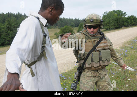 Un soldat de l'armée géorgienne de la Compagnie Alpha, Batumi Georgian Bataillon d'infanterie légère de l'armée américaine recherche un soldat du 1er Bataillon, 4e Régiment d'infanterie, la réplication d'un civil, au cours d'un exercice de répétition de mission (MRE) au Centre de préparation interarmées multinationale (JMRC) dans Hohenfels, Allemagne, le 8 août 2013. L'Batoumi et 31e bataillons d'infanterie légère géorgienne conduite un MRE afin de former et d'être évalués sur les bataillons leur aptitude à mener des opérations de contre-insurrection et de combat et s'intégrer dans une équipe de combat du régiment du Corps des marines déployés à l'appui de la sécurité internationale assista Banque D'Images