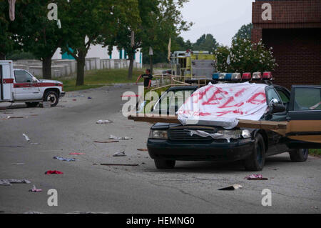 Un help sign, peint sur un drap blanc, couvre l'épave d'un véhicule de police au cours de la réponse dynamique 13-2 ici, 10 août. Les nombreux véhicules sont placés de façon spécifique pour chaque exercice, puis recueillis avant l'événement suivant. 'À la fin de l'exercice, nous allons lever la fourche ces voitures dans ce que j'appelle le cimetière de voiture, prêt pour la prochaine utilisation," a déclaré le sergent. 1re classe Brad Staggs, Muscatatuck Urban Training Centre Officier des affaires publiques et un soldat avec la Garde nationale de l'Indiana de Indianapolis. (U.S. Photo de l'armée par la CPS. Bradley J. Wancour, 13e Détachement des affaires publiques), même la cuisine Banque D'Images