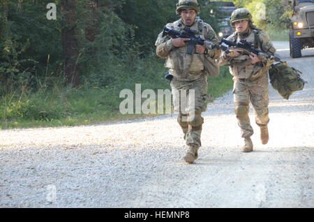 Les soldats de l'armée géorgienne de Delta Entreprise, 31e bataillon de chasseurs se précipitent à l'aide d'agents locaux, reproduit par les acteurs civils, au cours d'un exercice de répétition de mission (MRE) au Centre de préparation interarmées multinationale (JMRC) dans Hohenfels, Allemagne, 14 août 2013. L'Batoumi et 31e bataillons d'infanterie légère géorgienne conduite un MRE afin de former et d'être évalués sur les bataillons leur aptitude à mener des opérations de contre-insurrection et de combat et s'intégrer dans une équipe de combat du régiment du Corps des marines déployés en appui à des opérations de la Force internationale d'assistance à la sécurité en Afghanis Banque D'Images