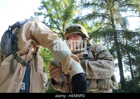 Un soldat de l'armée géorgienne de Delta Entreprise, 31e Bataillon d'infanterie légère donne à l'aide d'un local national, reproduite par un rôle civil, au cours d'un exercice de répétition de mission (MRE) au Centre de préparation interarmées multinationale (JMRC) dans Hohenfels, Allemagne, 14 août 2013. L'Batoumi et 31e bataillons d'infanterie légère géorgienne conduite un MRE afin de former et d'être évalués sur les bataillons leur aptitude à mener des opérations de contre-insurrection et de combat et s'intégrer dans une équipe de combat du régiment du Corps des marines déployés en appui à des opérations de la Force internationale d'assistance à la sécurité dans l Banque D'Images