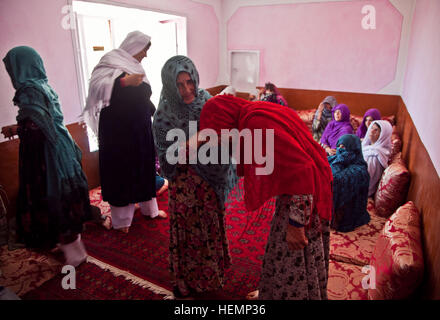 Deux femmes afghanes saluent lors d'un séminaire médical à Deh au district de yak, la province de Ghazni, Afghanistan, le 19 août 2013. Cinquante hommes, femmes et enfants de Pajak village et ses environs ont assisté à la conférence médicale, qui couvre des sujets tels que les premiers soins d'urgence, de l'assainissement, les techniques d'accouchement, et la nutrition. (U.S. Photo de l'armée par la CPS. Jessica Reyna DeBooy/libérés) Enduring Freedom 130820-A-SL739-001 Banque D'Images