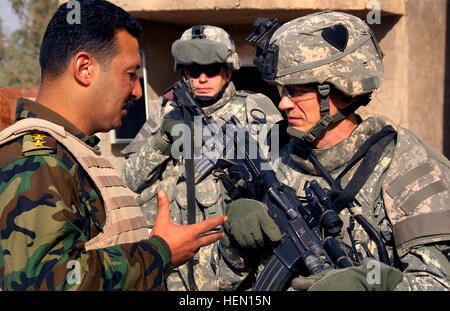 Le capitaine de l'Armée américaine Thomas Melton, commandant de troupe Alpha, 1er Escadron, 75e Régiment de cavalerie, 2e Brigade Combat Team, 101st Airborne Division traite de la mission avec son homologue du 4e Bataillon, 1e Brigade, 6e Division de l'armée iraquienne, dans Bakariya, l'Iraq, le 4 décembre. 2e Brigade Combat Team-soldat 69553 Banque D'Images