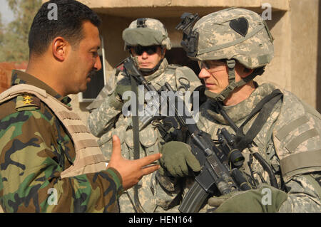 Le capitaine de l'Armée américaine Thomas Melton, commandant de troupe Alpha, 1er Escadron, 75e Régiment de cavalerie, 2e Brigade Combat Team, 101st Airborne Division traite de la mission avec son homologue du 4e Bataillon, 1e Brigade, 6e Division de l'armée iraquienne, dans Bakariya, l'Iraq, le 4 décembre. Mission de recenser 69553 Banque D'Images