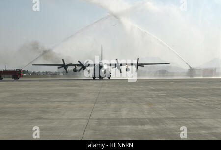 Deux camions incendie pulvériser de l'eau plus d'un C-130 Hercules qu'il circule sur la piste de l'aéroport international de Kaboul, 9 octobre 2013. Deux avions-cargos ont été consacrées au cours d'une cérémonie officielle en présence de forces de sécurité nationale afghanes et la Force internationale d'assistance ainsi que des hauts dirigeants de la République islamique d'Afghanistan des dignitaires. L'Afghan Air Force a pris livraison de ses deux premiers avions cargo C-130 qui stimuleront les FSNA de capacités militaires à ils assumer la direction de la sécurité de leur pays. (U.S. Photo de l'armée par le sergent. Richard Andrade, Banque D'Images