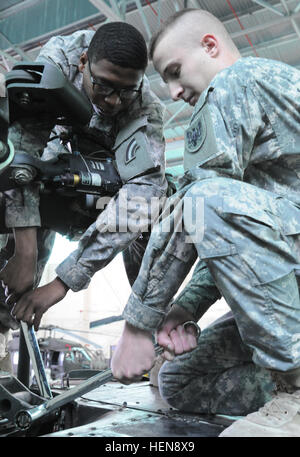 New York Garde nationale la CPS. Anthony Roberts, de la Compagnie B, 642e Bataillon de soutien à l'aviation dans la région de Ronkonkoma, N.Y., et réserve de l'Armée de Sgt. Jonathan Vermeulen, de la Compagnie B, 90e Bataillon de soutien à l'aviation dans la région de Fort Worth, Texas, déposer le lien de ciseaux sur la cellule's tête de rotor principal tout en haut d'un UH-60 Black Hawk au United States Army Aviation de réserve et de soutien, de Fort Hood, au Texas. (Photo par le Capitaine Alan S. Moss, Affaires publiques du Commandement de l'Aviation 11) New York aviation garde les chefs de service au Koweït, d'économiser de l'argent de la formation entre les volets du capot 130106-A-ZZ999-001 Banque D'Images