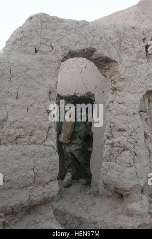 Une armée nationale afghane (ANA) Commando, 2e compagnie, 3e Kandak d'opérations spéciales (SOK) entre dans un composé dans l'Perozi village, district de Panjwai, province de Kandahar, en Afghanistan, le 4 décembre 2013. La 3ème SOK a mené le jeu de perturber le contrôle des insurgés et prévenir d'autres dispositifs explosifs de mise en place et les armes d'attaques. (U.S. Photo de l'armée par le sergent. Bertha A. Flores/ libéré) Perozi déminage 131204-A-LW390-065 Banque D'Images
