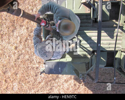 Prises de l'hélicoptère, les soldats de la 441e Transportation Co., de New Orleans, la connexion d'un véhicule pour slingload dans le cadre de leur mission, à des opérations de port formation en décembre à Fort Eustis en Virginie, d'un équipage de l'hélicoptère, les membres du 1er Bataillon, 228e Régiment d'aviation, Ft. Hover Eustis en prévision de l'exécution d'un coffre-fort et d'ascenseur. Photographe : Aumônier (CPT) Aaron Laenger, 438th BN Trans, Houston, TX Vue d'en haut - de brancher le véhicule pour un vol 131216-A-AL438-002 Banque D'Images