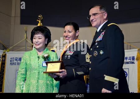 La Première armée américaine Sgt. Donna Swan, affectés au siège et de l'Administration centrale, l'entreprise est reconnue pour son implication communautaire et le service désintéressé au cours de l'International de peuple à peuple (PTPI) banquet, avec le général Curtis M. Scaparrotti, droite, le commandant des forces américaines en Corée, et le Dr Kim Gil Youn, présidente de PTPI Corée Siège national, à l'hôtel Grand Ambassador Hotel à Séoul, Corée du Sud, le 20 décembre 2013. (U.S. Photo de l'armée par le sergent. Luc Graziani/libérés) U.S. Army Première Sgt. Donna Swan, affectés au siège et de l'Administration centrale, l'entreprise est reconnue pour sa communauté outrea Banque D'Images