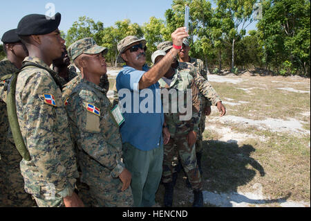 Manny Ochoa, un spécialiste de la récupération du personnel de l'Armée américaine au sud, en bleu, démontre un compteur d'air que Dwyer mesure la vitesse du vent pour les soldats de l'Armée de la République dominicaine au cours de la zone d'atterrissage de l'hélicoptère lors d'une formation axée sur la protection de la force/la récupération du personnel expert en la matière change au 5e Brigade d'infanterie dans la région de Barahona, République dominicaine, 11 mars 2014. La République dominicaine les soldats s'aider à la protection de la force au cours de l'exercice à venir au-delà de l'horizon qui se tiendra ici à Barahona, d'avril à juin 2014. BTH est un exercice humanitaire annuel Banque D'Images