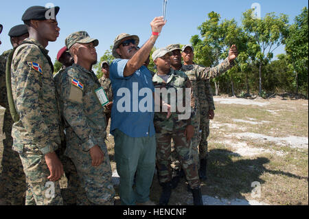 Manny Ochoa, un spécialiste de la récupération du personnel de l'Armée américaine au sud, en bleu, démontre un compteur d'air que Dwyer mesure la vitesse du vent pour les soldats de l'Armée de la République dominicaine au cours de la zone d'atterrissage de l'hélicoptère lors d'une formation axée sur la protection de la force/la récupération du personnel expert en la matière change au 5e Brigade d'infanterie dans la région de Barahona, République dominicaine, 11 mars 2014. La République dominicaine les soldats s'aider à la protection de la force au cours de l'exercice à venir au-delà de l'horizon qui se tiendra ici à Barahona, d'avril à juin 2014. BTH est un exercice humanitaire annuel Banque D'Images