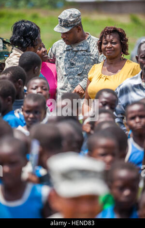 Les enseignants camerounais et l'école les enfants se rassemblent autour de maître de l'armée américaine le Sgt. John Reid, 369e Brigade, soutien de la Garde Nationale de New York, à l'extérieur de Douala, Cameroun, 19 mars 2014. Le sergent-chef. Reid, organisé et a recueilli de l'argent parmi d'autres soldats à faire don de la livraison pour une école locale dans le besoin. (U.S. Photo de l'armée par le sergent. Justin P. Morelli / Relâché) Accord Central 14, un partenariat pour un coffre-fort, stable et sûr du Sud 140319-A-PP104-249 Banque D'Images