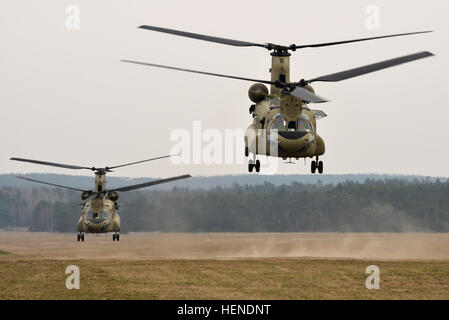 12e Brigade d'aviation de combat deux CH-47 Chinook soulever le Drop Zone Bunker dans Grafenwoehr après l'aspiration de parachutistes, affecté au 1er bataillon du 503e Régiment d'infanterie, 173ème Infantry Brigade Combat Team (Airborne) lors d'un bras combiné-exercice de tir réel au 28 mars 2014. L'ensemble bras-exercice de tir réel a été effectuée à la 7e armée du commandement multinational interarmées et secteurs d'entraînement Grafenwoehr Hohenfels afin de préparer la 12e Brigade d'aviation de combat en Afghanistan pour assurer des évacuations médicales et d'appui tactique à la Force internationale d'assistance à la sécurité forc Banque D'Images