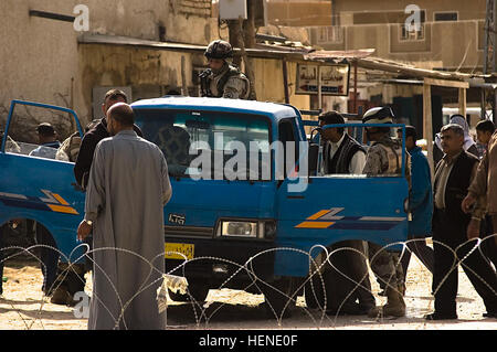 Des soldats iraquiens à partir de la 4e Brigade, 9e Division de l'armée iraquienne Recherchez un camion appartenant à un résident Abayachi à l'entrée du bâtiment du conseil de ville dans le village de Abayachi, au nord de Bagdad, le 2 mars. Les soldats irakiens qui travaillent avec la Compagnie B, 1er Bataillon, 14e Régiment d'infanterie, 2e Stryker Brigade Combat Team, "Warrior", 25e Division d'infanterie, la Division multinationale de Bagdad - assurer la sécurité de l'enceinte alors que les militaires de coopération B, 1er Bn., 14ème Inf. Regt. mener des activités de jour de paie pour les fils de l'Iraq (Abna al Iraq). Appuyer les activités de jour de 79513 soldats Banque D'Images