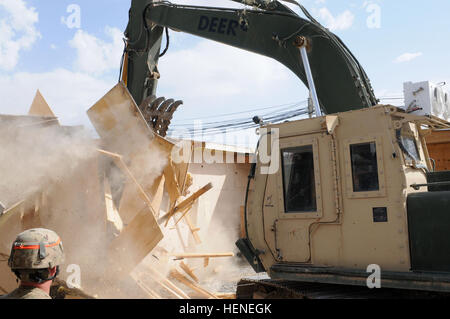 Originaire de Phoenix, le Colonel Mark D. Collins, commandant du Fort Bragg, N.C., 82e Brigade de soutien et les États-Unis Commande centrale de récupération du matériel, de l'élément utilise un excavateur hydraulique de démolition d'un bâtiment sur un site de déconstruction le 16 avril à l'aérodrome de Kandahar, Afghanistan. Soldats de Summerville, S.C., 1223e compagnie du génie, la Garde nationale de Caroline du Sud, attaché à la 82e et l'EARM SB-Little Rock, Ark., 489th Engineer Battalion, travaillent un ingénieur projet au site et a donné quelques conseils sur Collins fonctionnement du véhicule lourd. (U.S. Photo de l'armée par le Sgt. 1re Banque D'Images