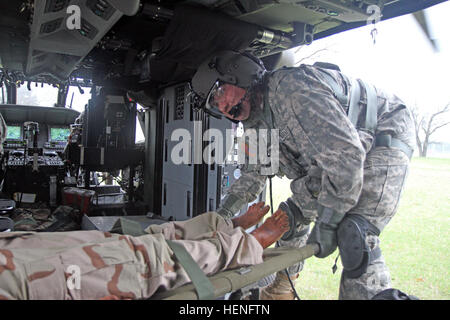 Le Sgt. 1re classe Michael Gilbert, Compagnie F, 1er Bataillon, 214e Régiment d'aviation, split basée entre Johnstown, en Pennsylvanie, et à Fort Knox, Ky., charge un "patient" sur son évacuation médicale HH-60M le 8 mai 2014 lors de la 86e Division de formation Soutien au combat de l'exercice de formation/Global Medic du 26 avril jusqu'au 16 mai sur Fort McCoy, Wisconsin (Etats-Unis) La société fait partie de la 11e commandement de l'Aviation, Fort Knox, Ky. Photo de M. Clinton, bois, 84e commandement de l'instruction des affaires publiques. Réserver Société Medevac affine ses compétences à CSTX-Global Medic 140508-A-HX393-081 Banque D'Images