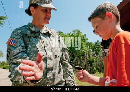 Le sergent de l'armée américaine. Jennifer Middleton, qui est de Panama City, Floride, montre 6niveleuse Chantz Curtis comment utiliser un compas pendant le III Corps d'armée et de l'Administration centrale du bataillon à leur école, Eastern Hills Middle School, le 30 mai 2014. Les soldats avec HHBN a passé une journée au Ranch Parrie Haynes au sud de Chicago avec plus de 300 enfants de EHMS. Le III Corps et de Fort Hood programme Adoptez une école militaire contribue les ressources et les services pour les établissements scolaires afin de favoriser l'intellectuelle, affective, sociale, et la croissance physique des enfants dans la grande région de Fort H Banque D'Images