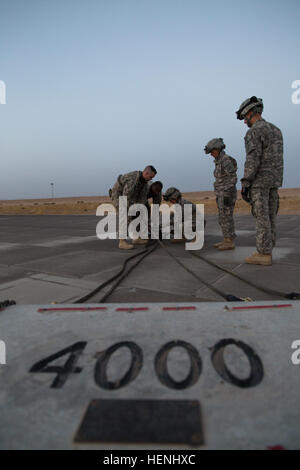 Les soldats de la 642e Bataillon de soutien à l'Aviation accrocher sling jambes pour un poids de 4 000 livres avant la nuit la charge sous élingue avec formation d'aviateurs de la 3e bataillon du 142e Bataillon d'hélicoptères d'assaut, le 5 juin 2014, au Camp Buehring, le Koweït. La 642e et 142e, tant dans le cadre de la 42e Brigade d'aviation de combat, la Garde Nationale de New York, sont déployés au Koweït dans le cadre de l'opération Enduring Freedom. (New York) La Garde nationale de l'armée photo par le Sgt. Harley Jelis/libérés) 642e Bataillon de soutien à l'aviation nuit charge sous élingue 140605-A-AR422-023 Banque D'Images