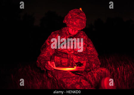 Le s.. Landon Nordby, un agent de la police militaire représentant le Commandement de la Police militaire du 200e et de Saint James, Minn., parcelles son premier point au cours de la nuit de la navigation terrestre à l'événement 2014 de la réserve de l'armée américaine de la concurrence meilleur guerrier, le 24 juin, à Joint Base McGuire-Dix-Lakehurst, New Jersey. Les guerriers étaient déposés à 1h00 et a eu quatre heures pour tracer et trouver leurs points carte dans l'obscurité complète. 2014 US Army Réserver meilleur guerrier - Nuit de la navigation terrestre 140624-A-XN107-100 Banque D'Images