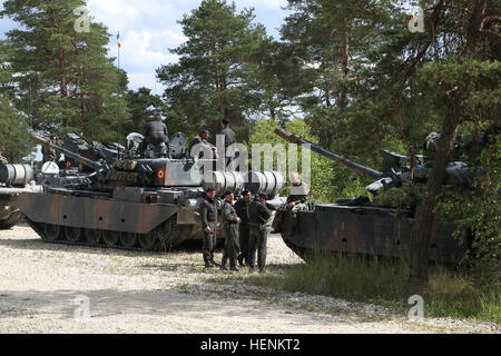 Soldats roumains en TR-85M1 Bizonul des chars de combat de la 284e bataillon se regrouper après une marche à tir réel au cours de l'exercice Combined Résoudre II à la zone d'entraînement Grafenwoehr Grafenwoehr, Allemagne, le 26 juin 2014. Résoudre combiné II est une action décisive des multinationales de l'environnement de formation à l'exercice multinational interarmées du commandement, Hohenfels et zones d'entraînement Grafenwoehr qui implique plus de 4 000 participants venus de 15 pays partenaires. Le but de l'exercice est de former et préparer une brigade multinationale américaine -conduit à fonctionner avec des partenaires multiples na Banque D'Images