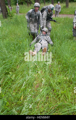 La FPC. Michael Nagle, originaire de Norco, en Californie et la FPC. Michael Frey natif de Galt, en Californie, les parachutistes du 2e Bataillon, affecté au 503e Régiment d'infanterie, 173e Brigade aéroportée, faites glisser la FPC. Michael Nixon, originaire de Pensacola, Floride, un parachutiste également affecté à la 173e Airborne, par l'intermédiaire d'un champ humide au cours d'un Combat épargnant de vie cours le 30 juin. La 173e Brigade aéroportée participe à un terrain non-exercice des forces canadiennes à la demande de la nation hôte afin d'augmenter la coopération en matière de sécurité dans la région. (U.S. Photo de l'armée par la CPS. Hector R./Membreno) Parution champ apprendre parachutistes medi Banque D'Images