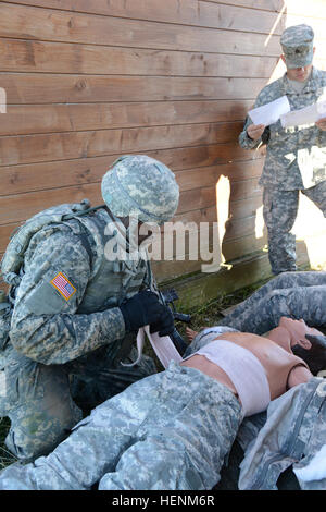 L'ARMÉE AMÉRICAINE Pvt. Richard Fletcher, avec l'armée américaine, une garnison Benelux applique un pansement sur un mannequin's trunk au cours de l'exercice guerrier meilleur sur la base aérienne de Chièvres, Belgique, 1 juillet 2014 (U.S. Photo de l'armée par Visual Spécialiste de l'information Pascal Demeuldre-Released) meilleur exercice guerrier, USAG Benelux 140701-A-RX599-124 Banque D'Images