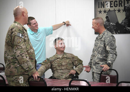 Le Sgt. Adam Hartswick, guerrier blessé blessé dans la bataille, et son ami le SPC. Jason Lingo, actuellement déployés au Koweït, rire avec la commande centrale de l'armée américaine le Sgt. Le major Ronnie R. Kelley lors d'une visite au Camp Arifjan, au Koweït, après la participation de Feherty Hartswick les troupes de l'opération de la Fondation Première sortie correcte 13 juillet 2014. Hartswick et Lingo sont amis depuis leur première année de secondaire à State College, Pennsylvanie- ils ont été en mesure de passer du temps ensemble tout en Hartswick était au Koweït. (U.S. Photo de l'armée par le Sgt. Tracy R. Myers, U.S. Army Central) Bittersweet reunion dans le désert 14071 Banque D'Images