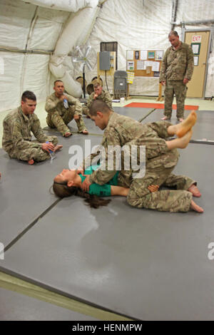 Le Sgt. Maria Acuna, une armée moderne combatives de niveau trois du Programme du Groupe de travail de l'instructeur avec Warhawk, montre la façon d'obtenir une position dominante aux soldats dans Warhawk TF 17 juillet à l'Aérodrome de Shindand. Soldats de terminer un bloc de 40 heures d'enseignement pour devenir certifié de niveau un MACP. Creuser en serres Warhawks combatives 140717-A-XP915-003 Banque D'Images