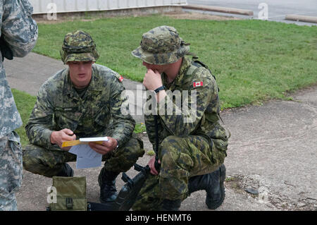 Les membres des Forces armées canadiennes, Royal Canadian Engineers, Cpl. Cameron Bigsby (gauche) de Saskatoon, Saskatchewan et le caporal. Brendon Gogo à partir de Winnipeg, Manatoba, tant les sapeurs de combat avec le 38 Régiment du génie canadien, consultez le manuel pour le détecteur de métal Gizmo en préparation de l'engin explosif lane. Dix-huit Canadiens ont été intégrés à 412e et 416e Ingénieur Ingénieur commande théâtre pendant le fonctionnement d'unités d'assaut de la rivière à Fort Chaffee, Ark., Juillet 14 à 26. Nos cousins du Nord, nous, ingénieurs de la Réserve du Canada s'entraînent ensemble 140718-A-FW423-266 Banque D'Images